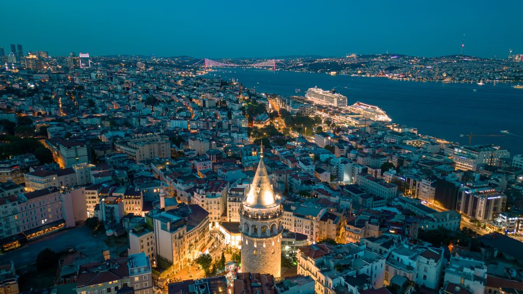Stunning aerial view of Galata Tower with illuminated Istanbul skyline at night.